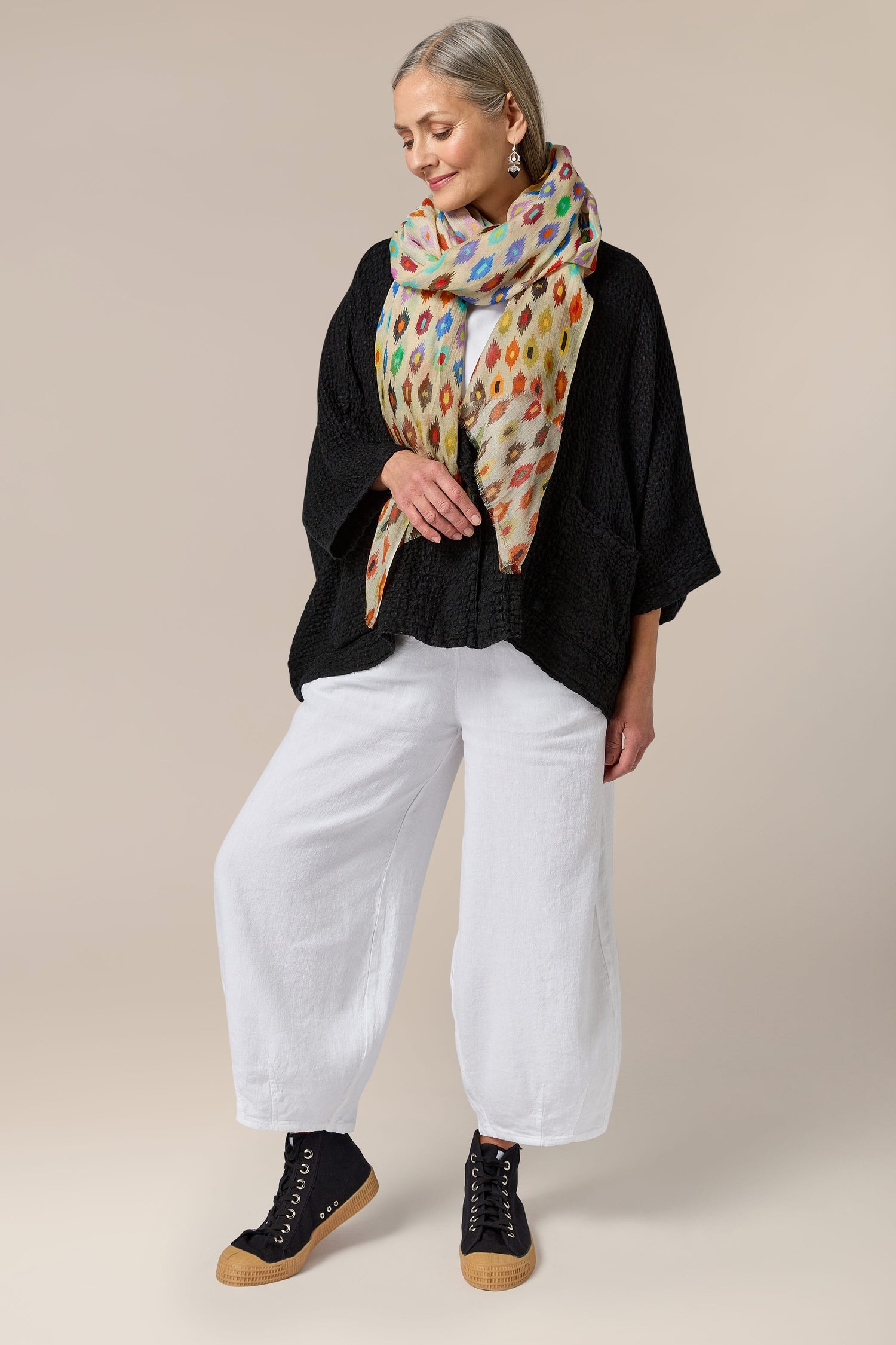 A woman wearing Twisted Linen Bubble Trousers with an elasticated waistband and a polka dot scarf.