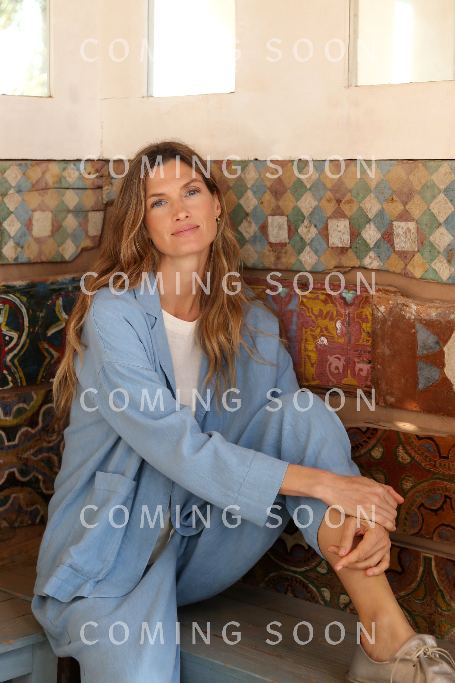 A woman in a light blue Twisted Linen Crop Bubble Trouser sits on a bench with one arm on her knee, in front of a colorful tiled wall. The words "COMING SOON" and code LAP5691-HTL are repeated across the image.