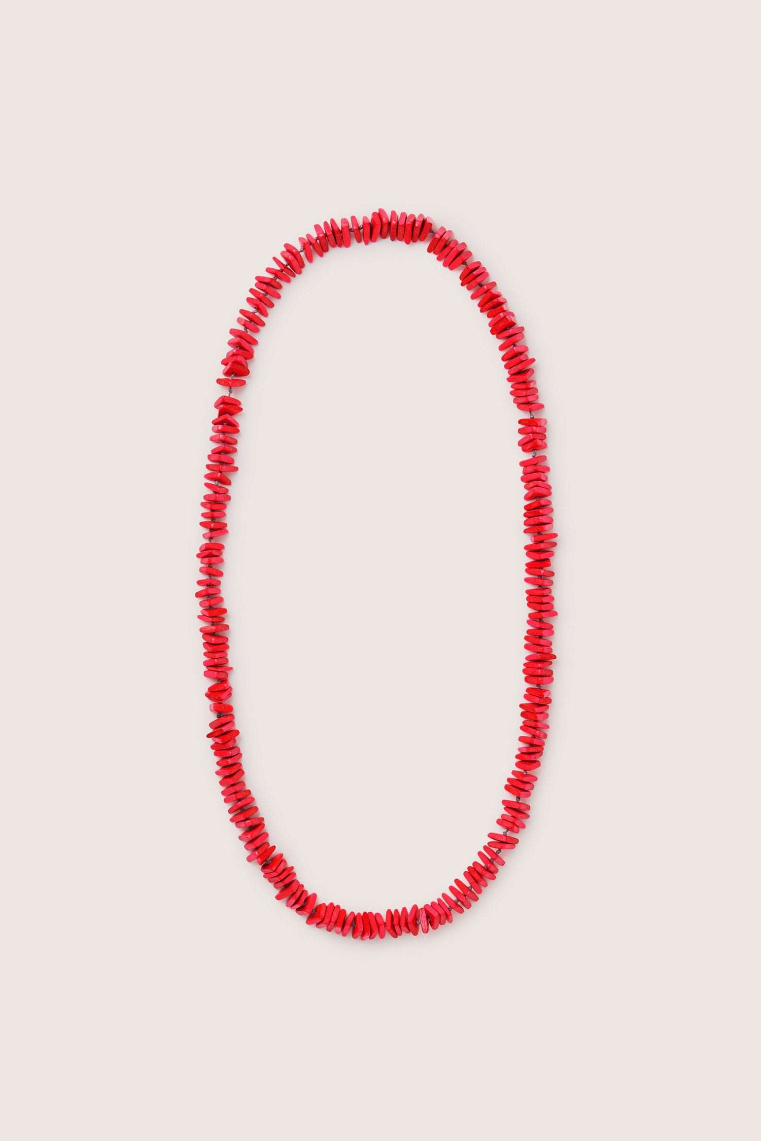 The Mini Triangles Wooden Necklace showcases the unique charm of handmade wooden jewelry with its delightful arrangement of small, intricately shaped red beads arranged in a single continuous strand.