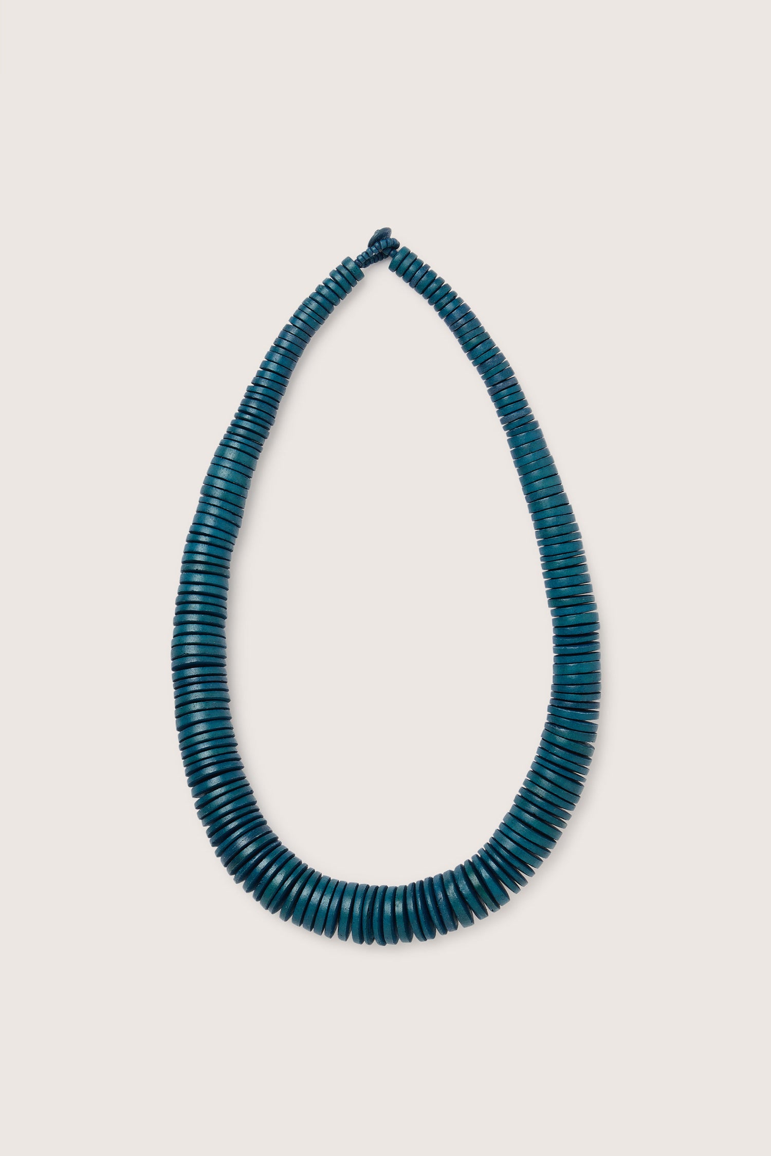 A handmade in the Philippines Graduated Coco Disc Necklace, featuring dark teal beads arranged in a loop on a plain background.