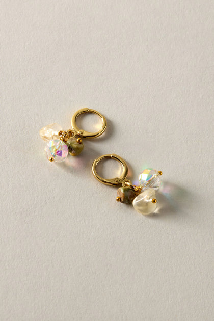 The Citrine and Rhyolite Bead Earrings, featuring gold hoops adorned with iridescent beads and pearls against a light gray background, highlight sustainable craftsmanship.