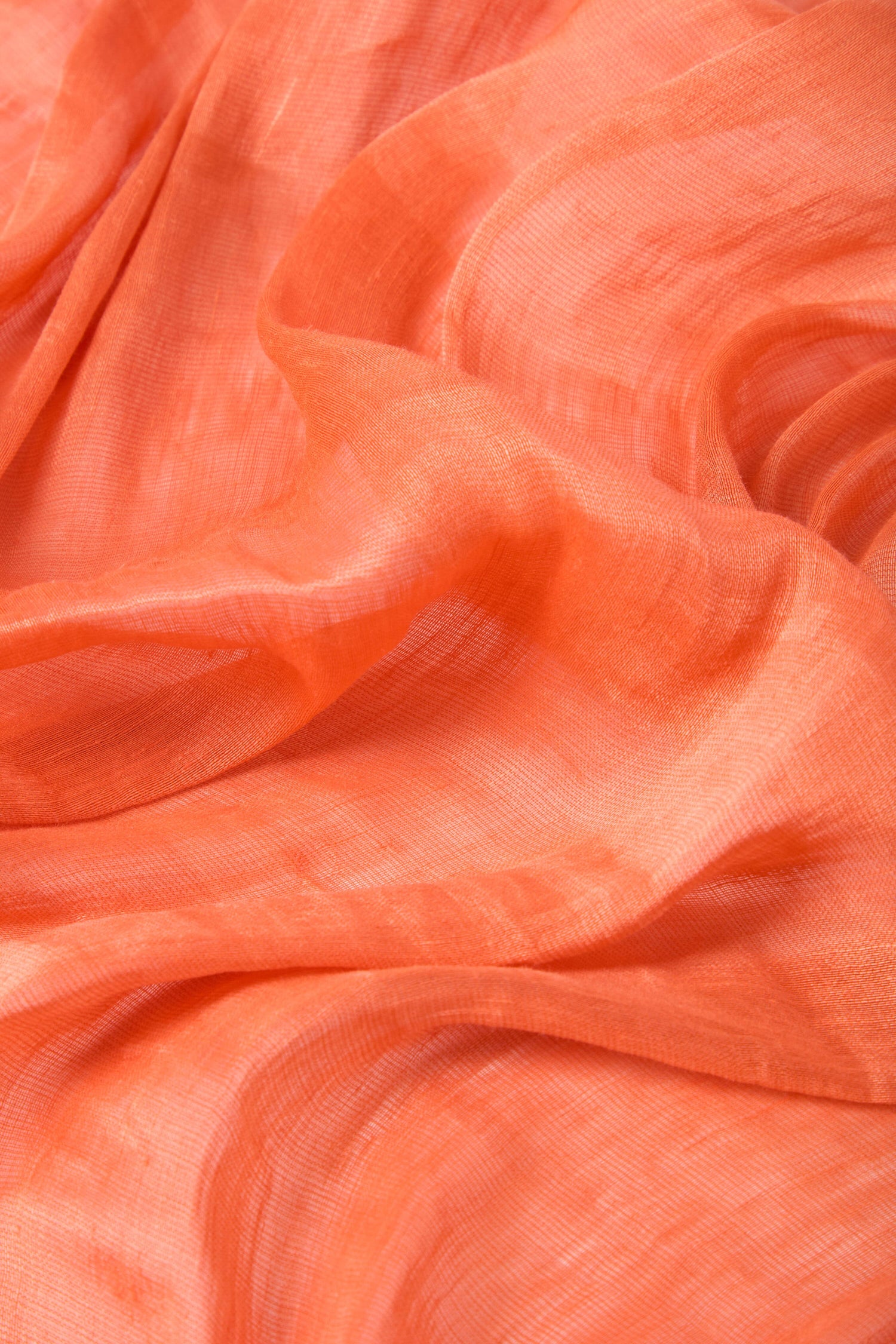 Close-up of an orange, sheer fabric with delicate folds and a smooth texture, reminiscent of a Soft Linen Scarf.