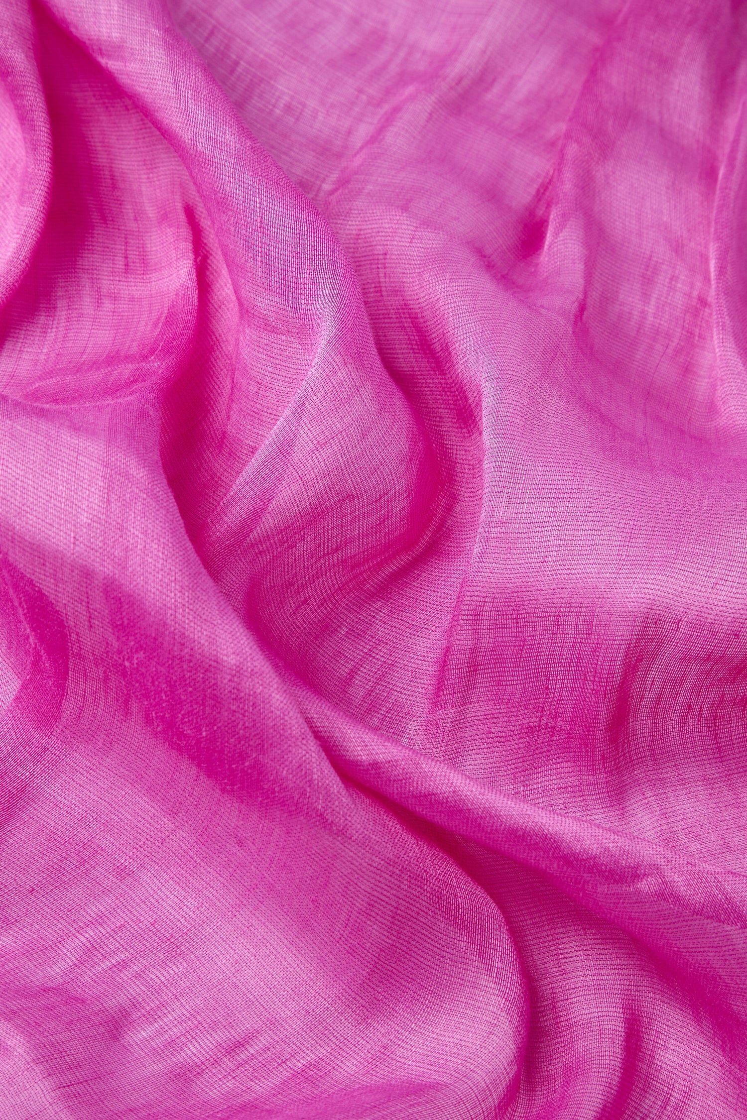 The Soft Linen Scarf boasts a bright pink fabric with a delicate, sheer texture, adorned with gentle folds and subtle variations in color. This luxurious design encapsulates elegance and style, ensuring each scarf is unique and cherished.