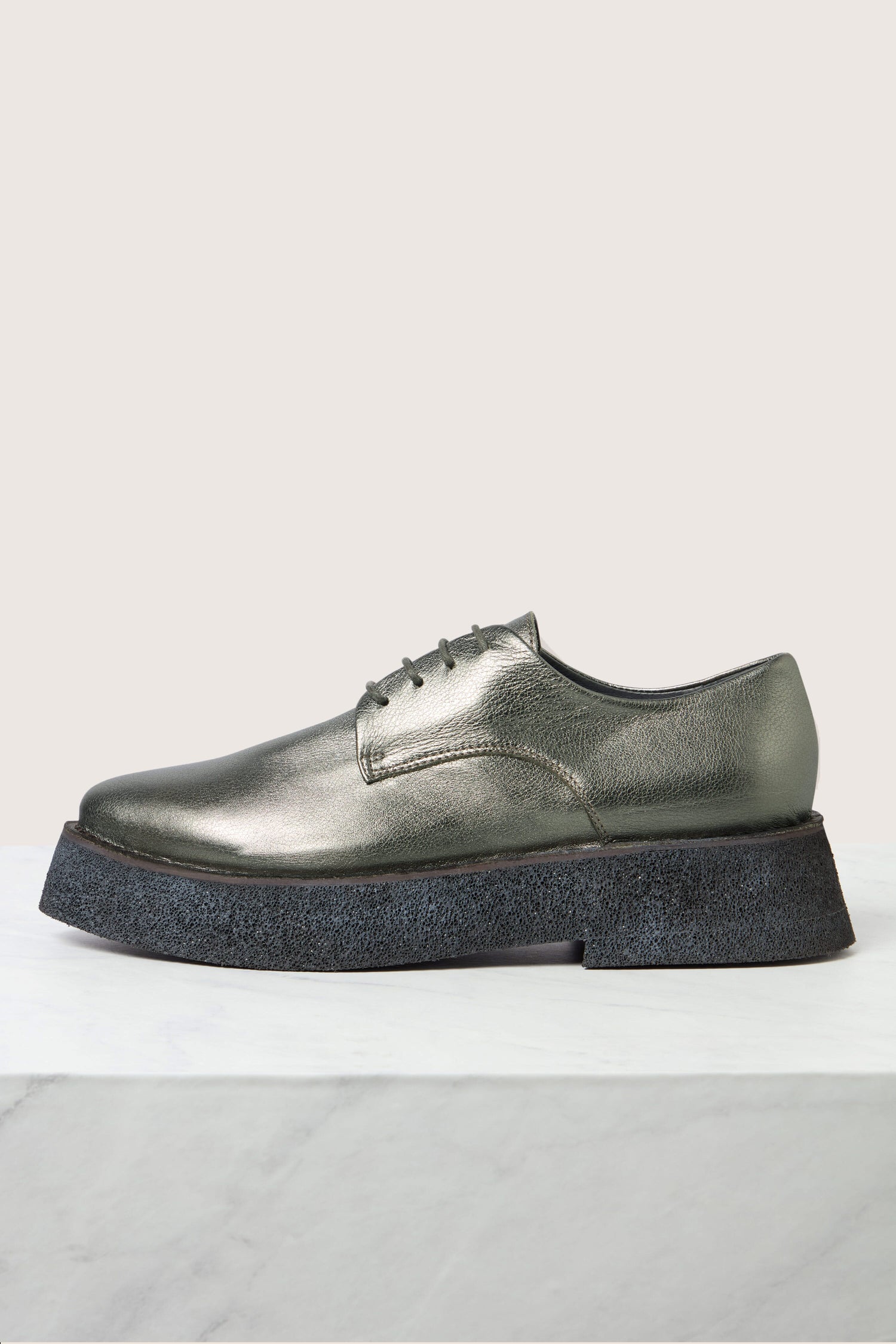 The Lace up Leather Brogues in metallic grey with black laces and a lightweight platform sole are displayed on a white surface against a light background.