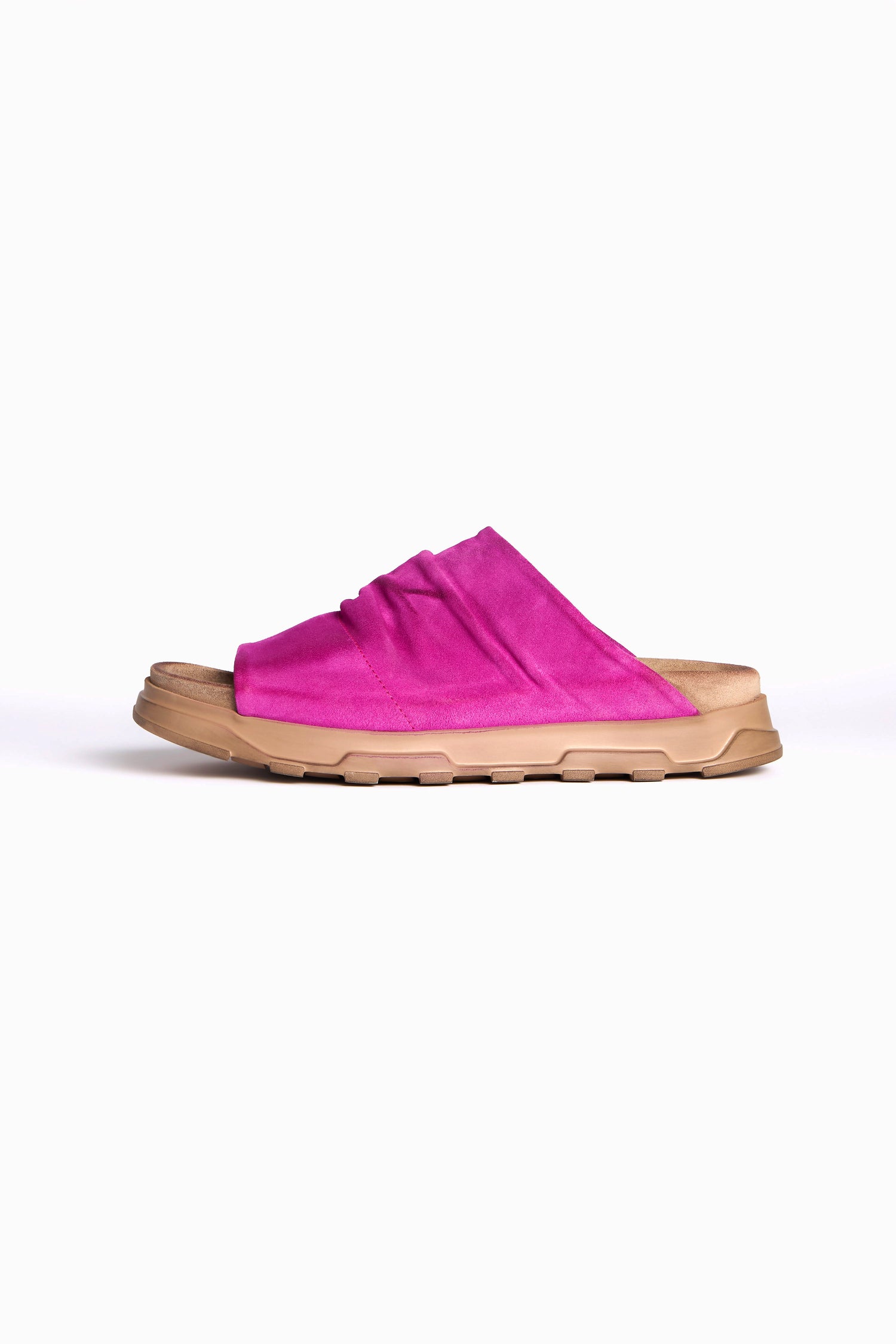 The Magenta Crushed Leather Sliders showcase a tan sole with a vibrant pink crumpled leather upper, providing slip-on convenience and all-day comfort. Displayed against a white backdrop, these sandals seamlessly blend style and ease.