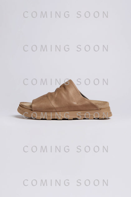 The Crushed Leather Sliders are shown against a light background with “COMING SOON” repeatedly overlaid in gray.