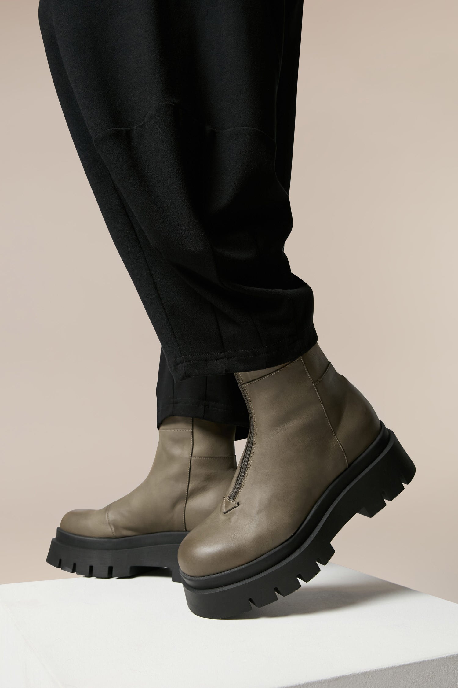 A man wearing a pair of stylish Platform Zip Front Leather Boots, showcasing exquisite Italian craftsmanship and Danish design elements.