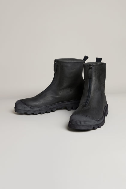The Black Zip Front Leather Boots, handcrafted in Italy from premium black leather with rugged rubber soles, are displayed against a plain light background.