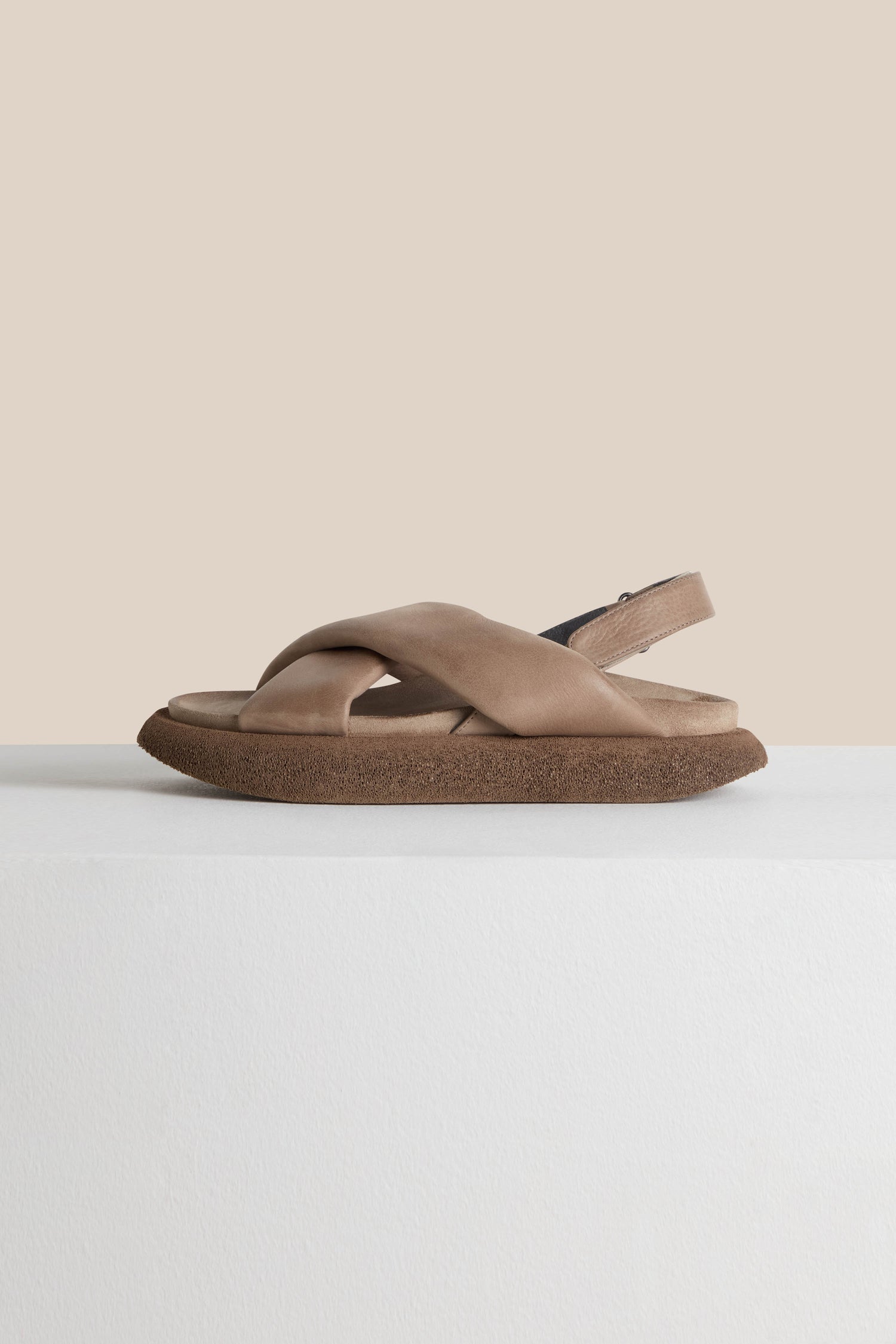 Exquisitely crafted Crossover Leather Sandals in beige, featuring slingback and crossover straps with a brown sole, beautifully displayed against a plain background, showcasing Scandinavian craftsmanship.