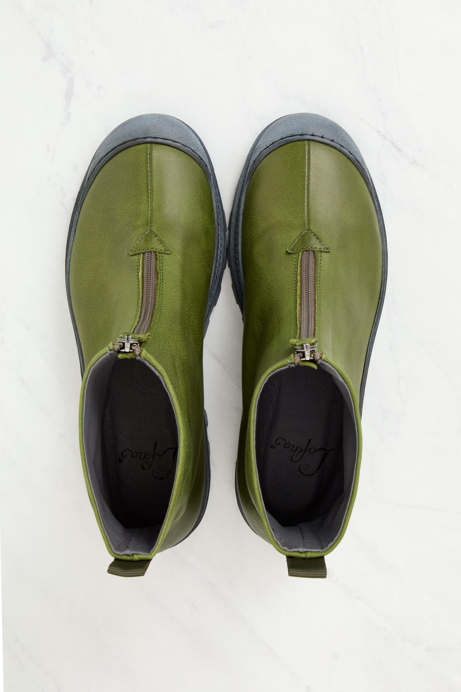 A pair of Zip Front Boots in green leather, showcasing Italian craftsmanship, resting on a marble surface.