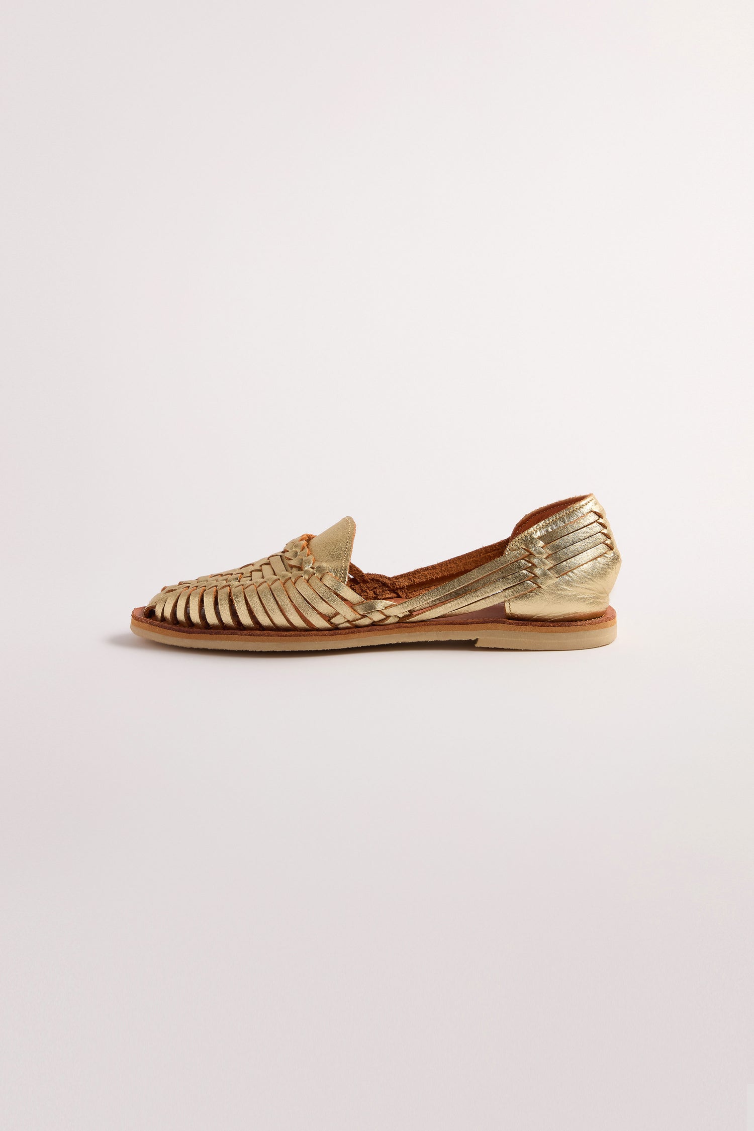 Displayed on a plain white background is a single Alegre Leather Huarache Sandal in gold, featuring a woven design and flat sole, handcrafted in Mexico.