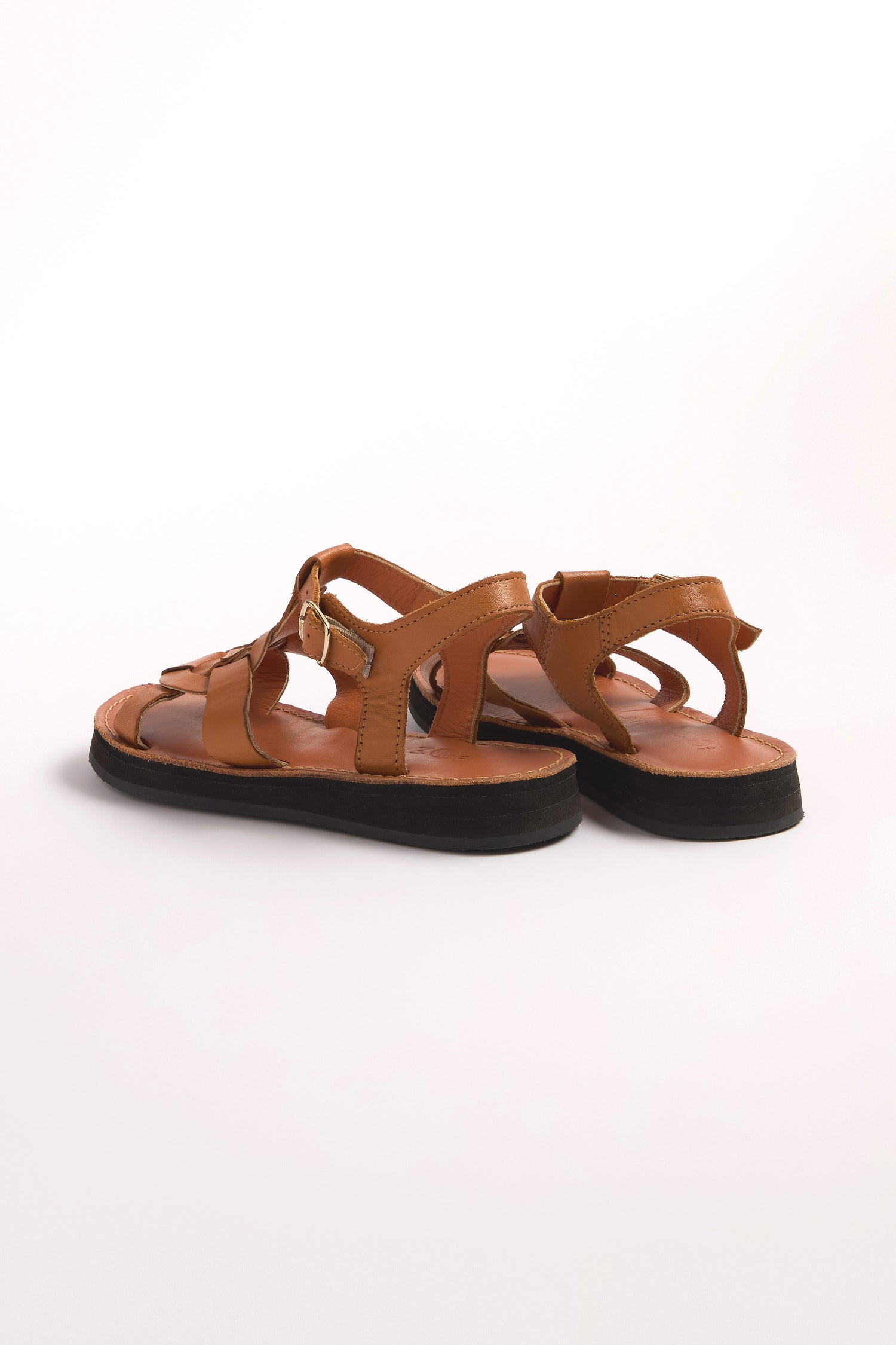 A pair of Tulum Leather Buckle Sandals, crafted from premium brown leather with cushioned sole comfort and black soles, seen from the back on a white background.