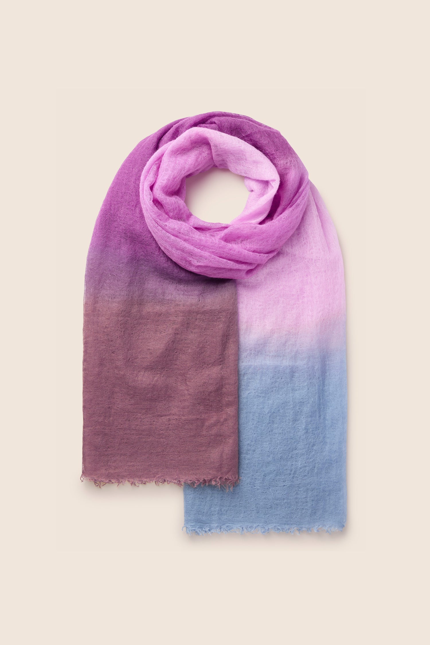 The St Tropez Cashmere Shawl is a luxurious piece featuring a gradient watercolour design that flows seamlessly from deep purple to lavender to light blue, crafted from soft and lightweight fabric.