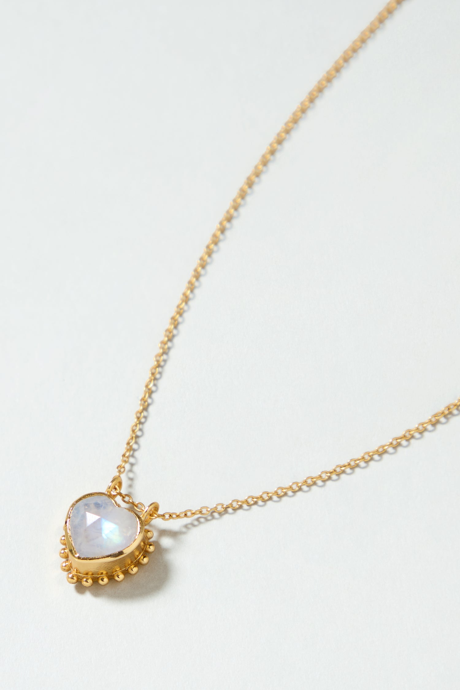 The Gold Plated White Moonstone Heart Necklace adds a touch of elegance to any outfit with its heart-shaped pendant and sophisticated design.