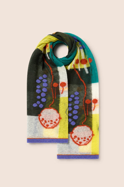 An Abstract Mohair Shawl from M.&Kyoko, featuring vibrant red circular designs, purple dots, and various abstract shapes in green, yellow, black, and white tones, laid flat on a light beige background. This wearable art accessory adds a touch of luxury to any outfit.