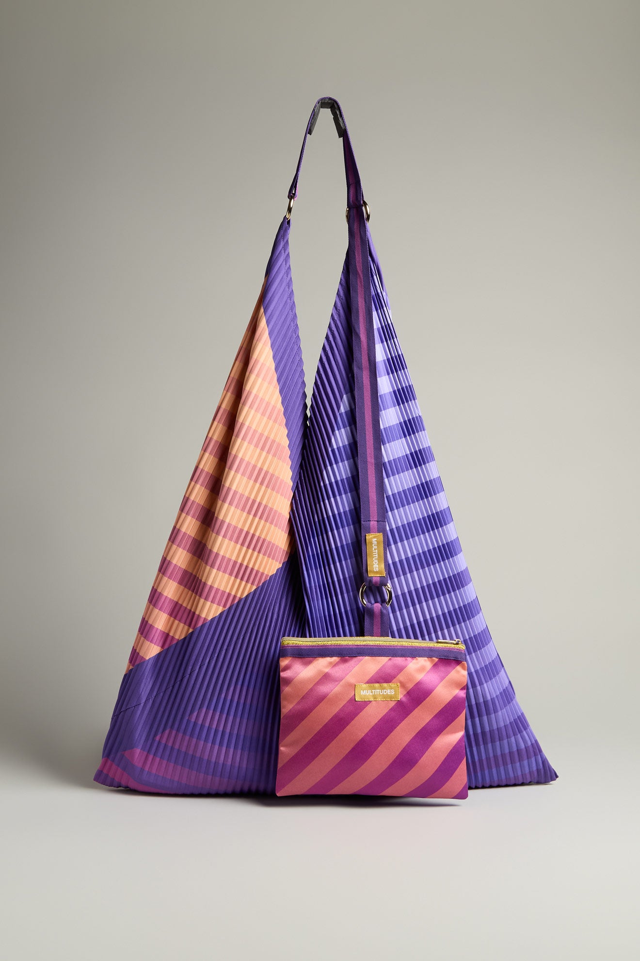 A Pleated Y Handbag in purple with diagonal stripes is displayed with a matching clutch on a gray background, highlighting sustainable design in this eco-friendly handbag pair.