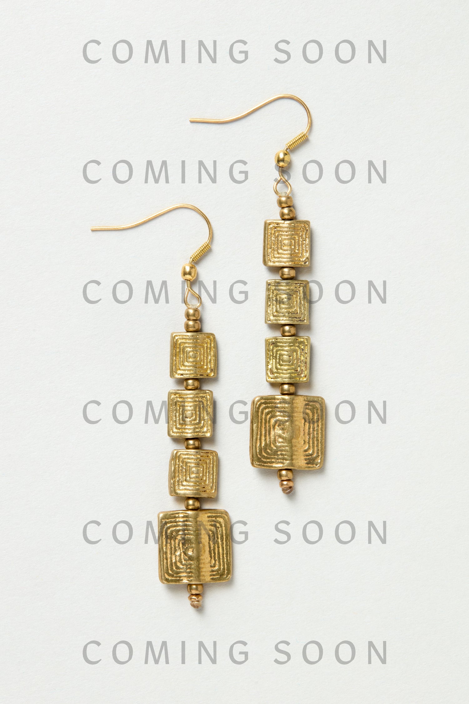 Engraved Squares Earrings (style NCECE175): gold dangle earrings with three stacked, textured square charms each, shown on a light background. "COMING SOON" is repeated over the image.