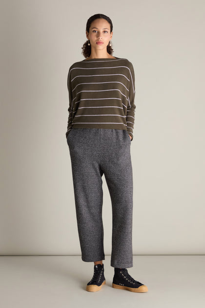 A person stands against a neutral background, clad in a striped long-sleeve top and the chic cropped-length Jaquard Jersey Trouser with a stretch waistband. Their hands rest in their pockets as they look directly ahead, paired with black sneakers.