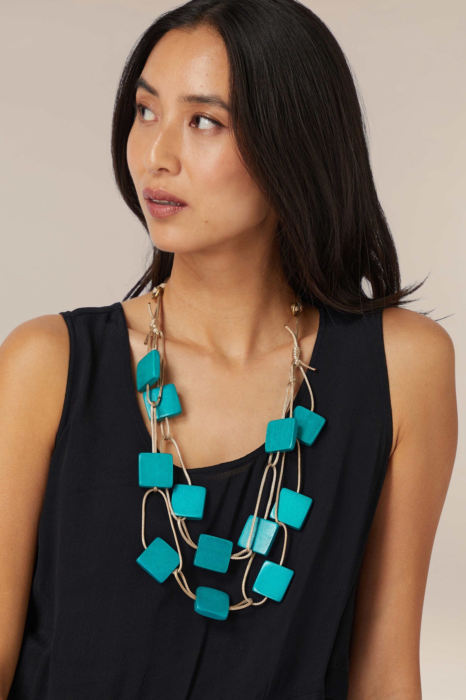 Woman wearing a black top and an adjustable length Aqua Cascade Squares Necklace.