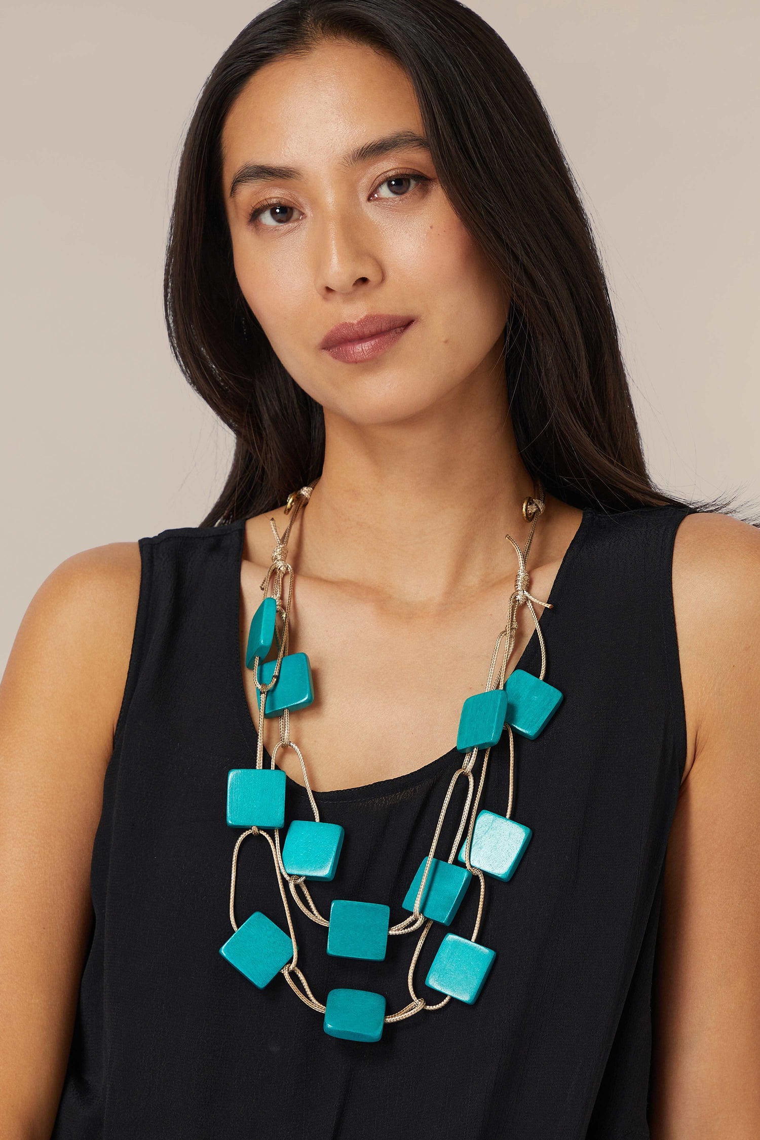 Woman wearing a black top and a turquoise Cascade Squares Necklace.