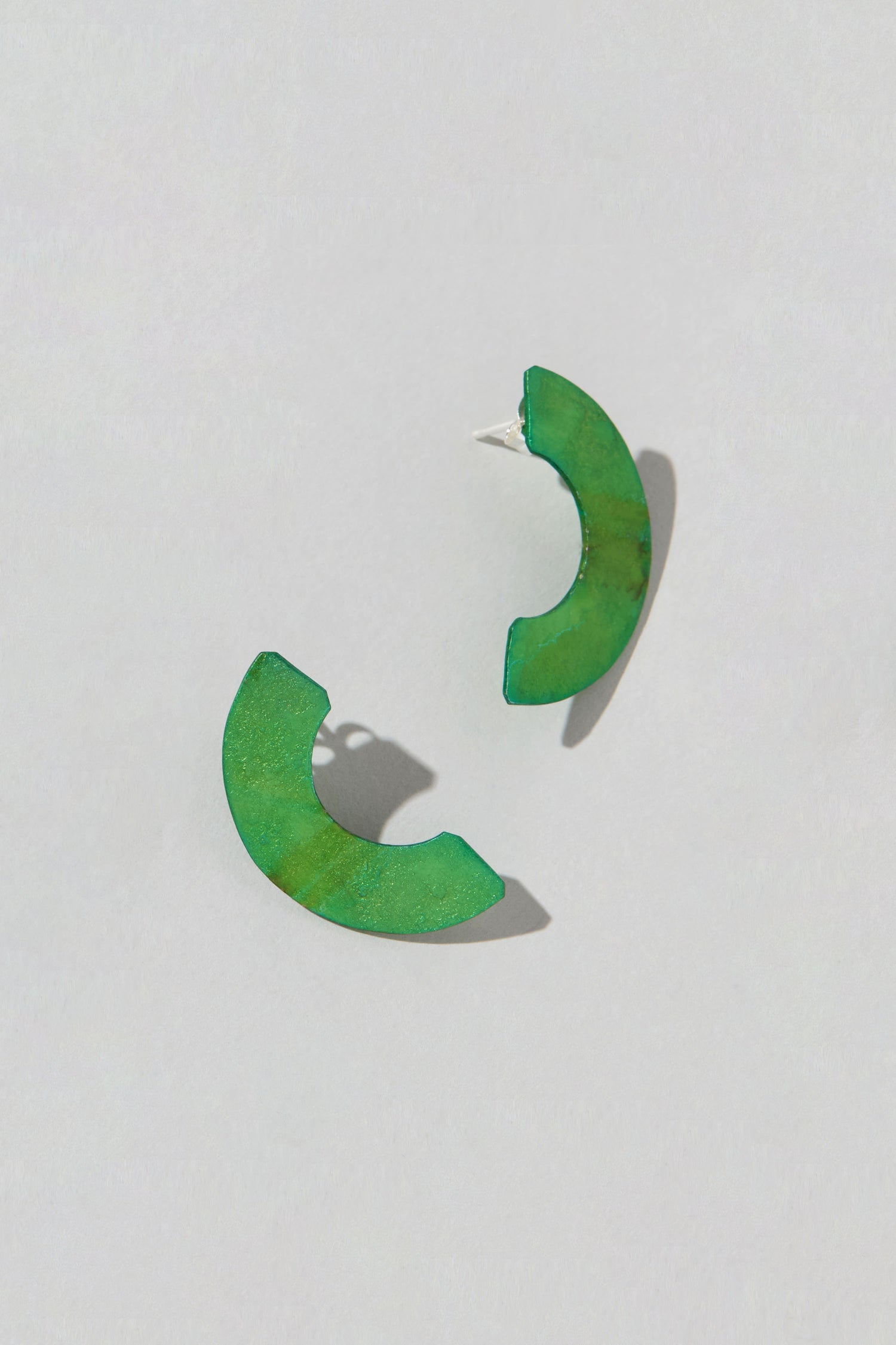 The Aluminium Crescent Earrings, labeled OAE399, elegantly rest in their half-circle green form on a neutral white background.