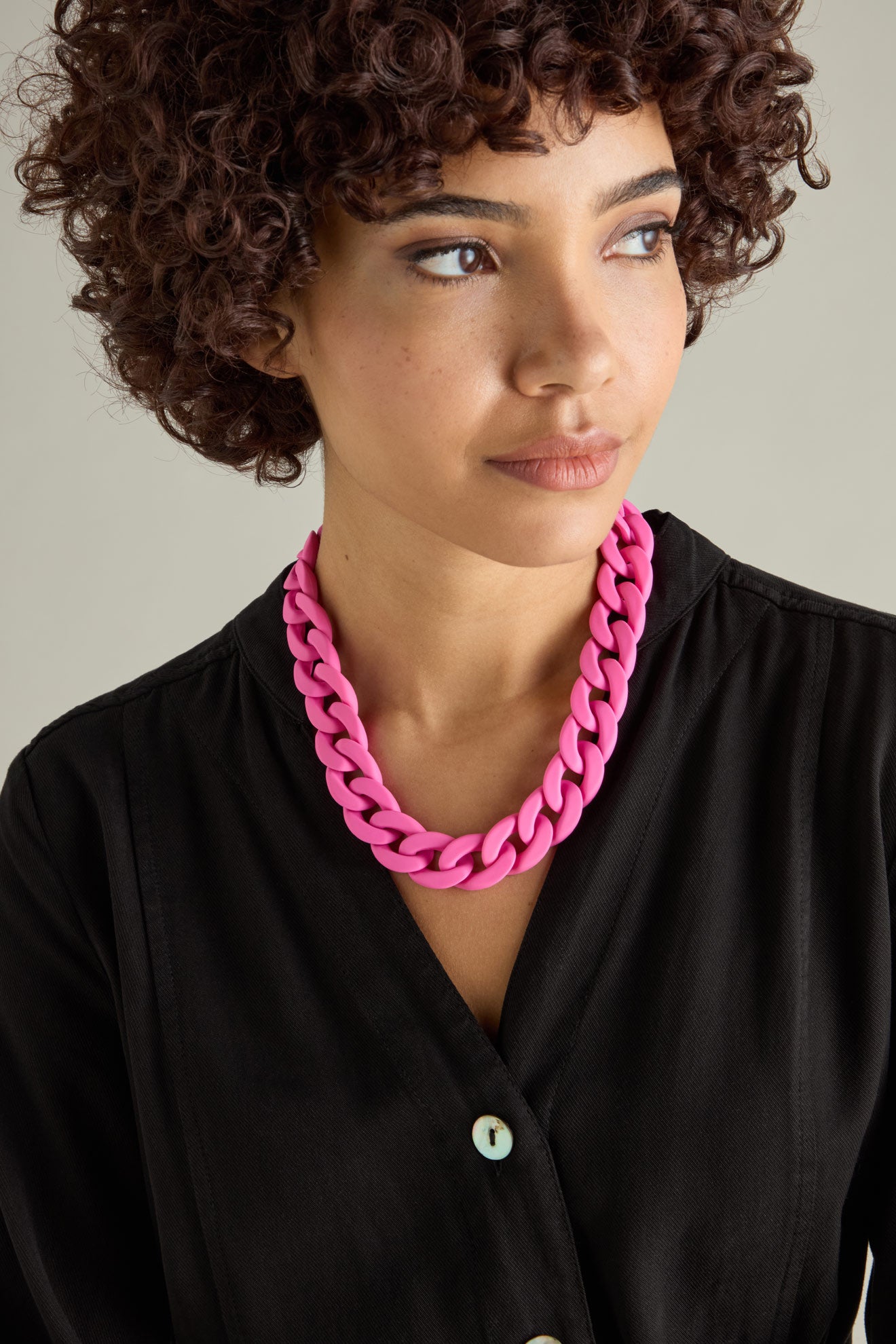 Person wearing a black shirt accessorized with the Colour Pop Link Necklace, looking to the side.