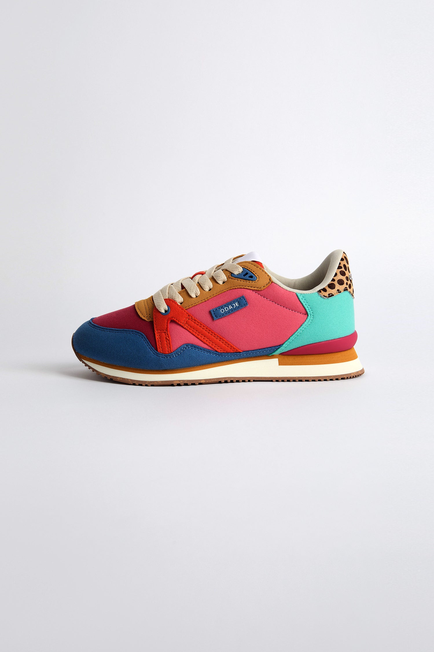 The Andree Trainers are colorful sneakers showcasing vibrant blue, red, pink, brown, and turquoise hues with a leopard print heel detail and a white recycled mesh sole.