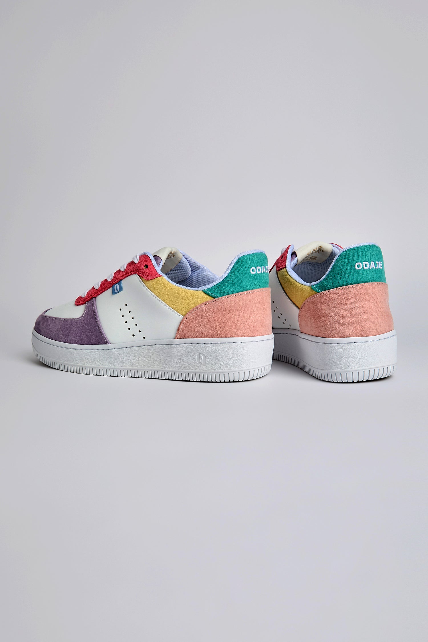 Meet the Maxence Trainers, colorful eco-friendly sneakers with vibrant vegan suede panels in purple, pink, yellow, green, and white on a light gray base—perfect for those who value bold style and sustainability.