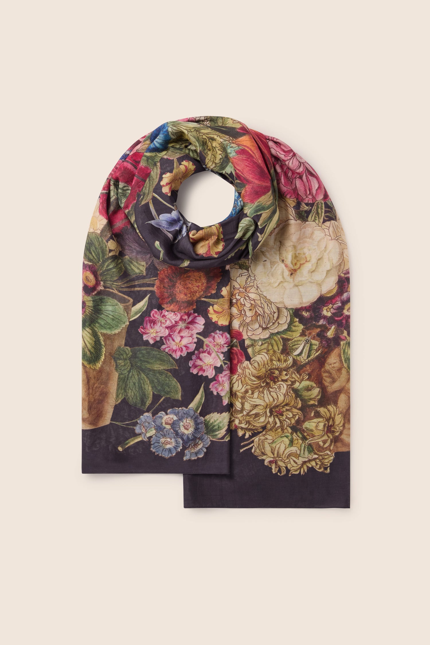 The Primula Scarf, a vibrant piece of sustainable fashion, features a floral print with an array of flowers in red, pink, yellow, and blue hues beautifully set against a dark background. Presented partially folded on a light backdrop, this eco-friendly scarf is as stylish as it is environmentally conscious.