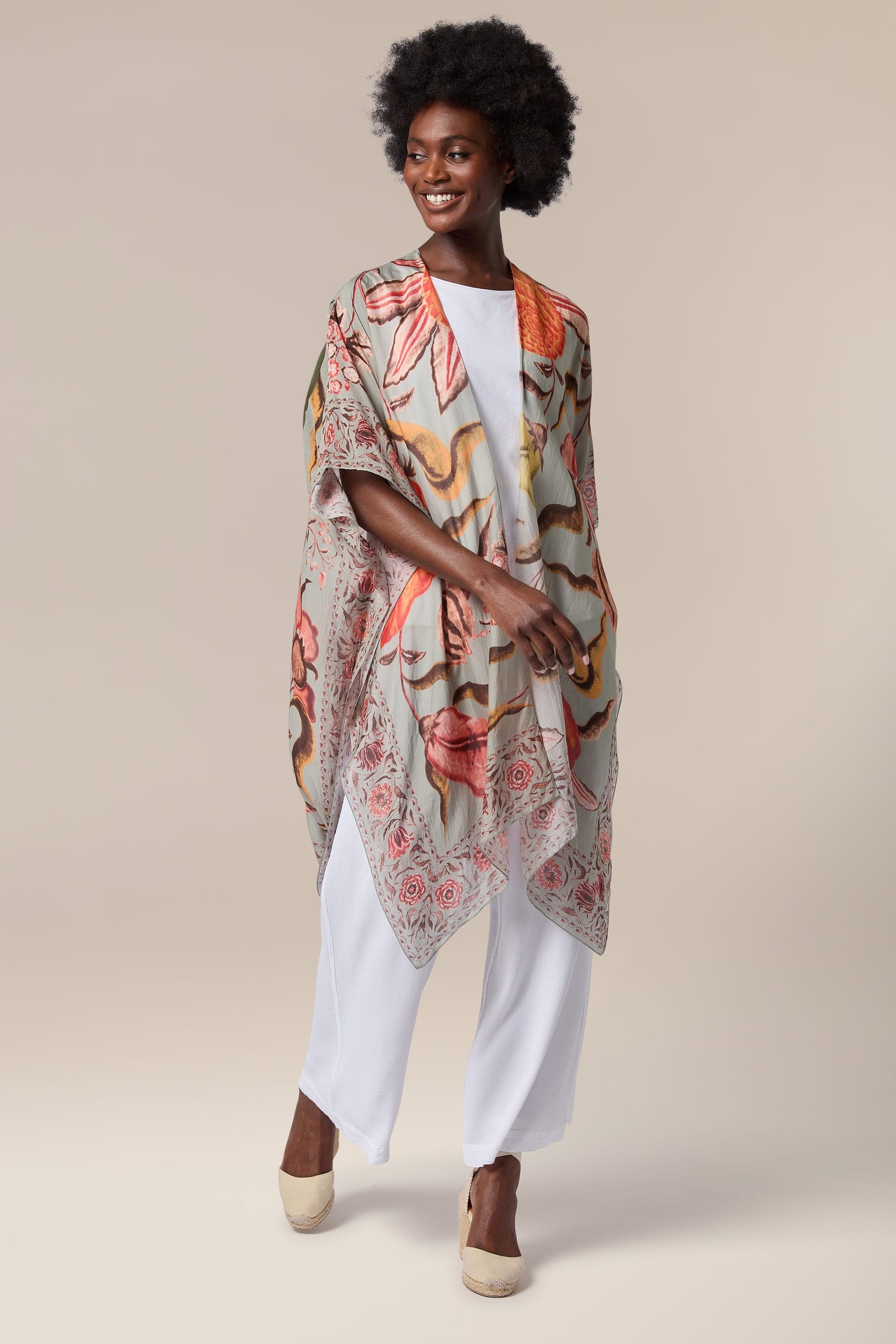 A black woman wearing a Joy Throwover, inspired by Indian textiles.