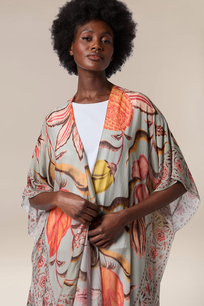 A woman wearing the Joy Throwover, a floral print kimono throwover.