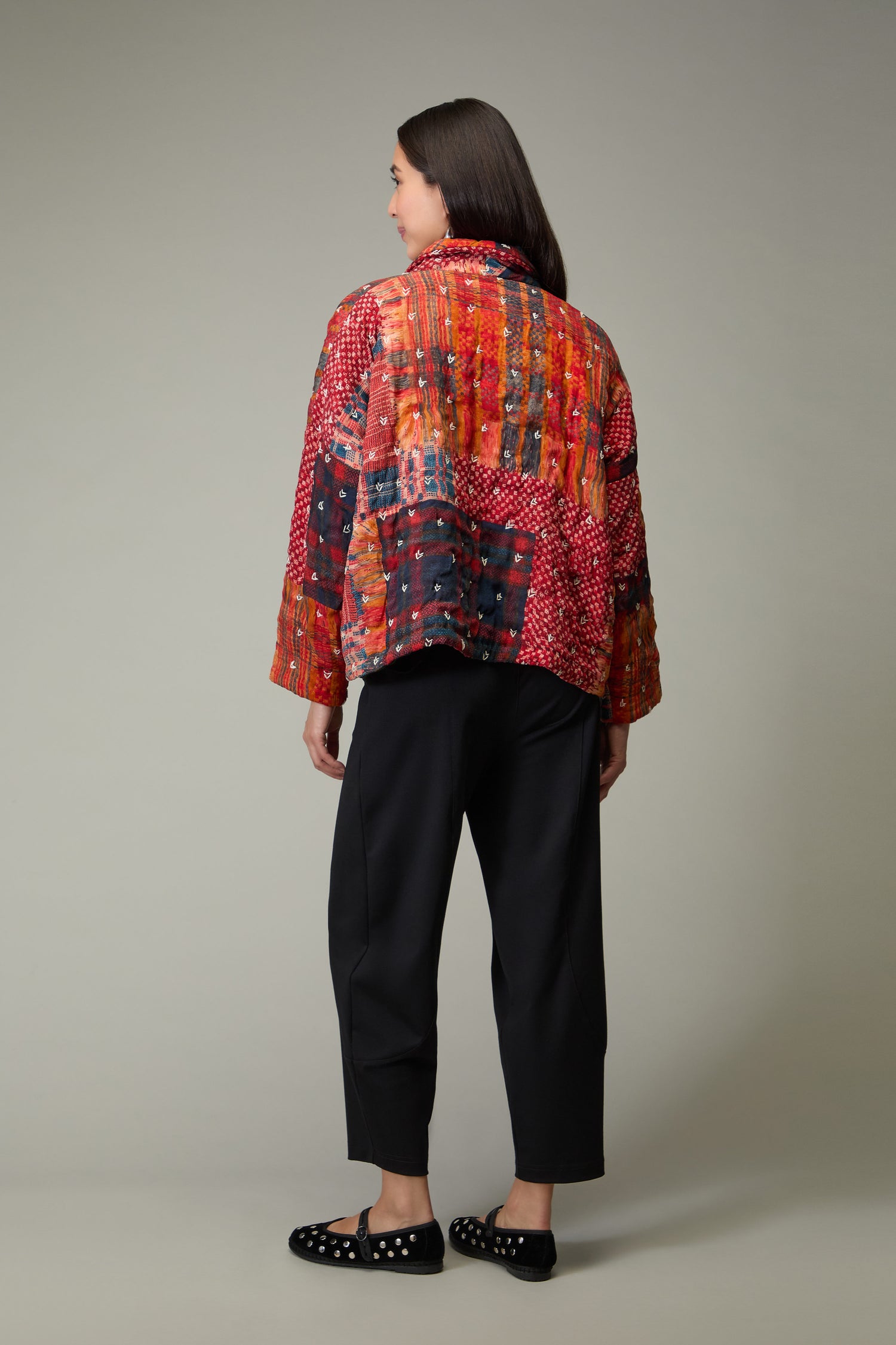 A person stands facing away, wearing the Padded Multi Check Padded Jacket, black pants, and black shoes with white dots, set against a plain background.