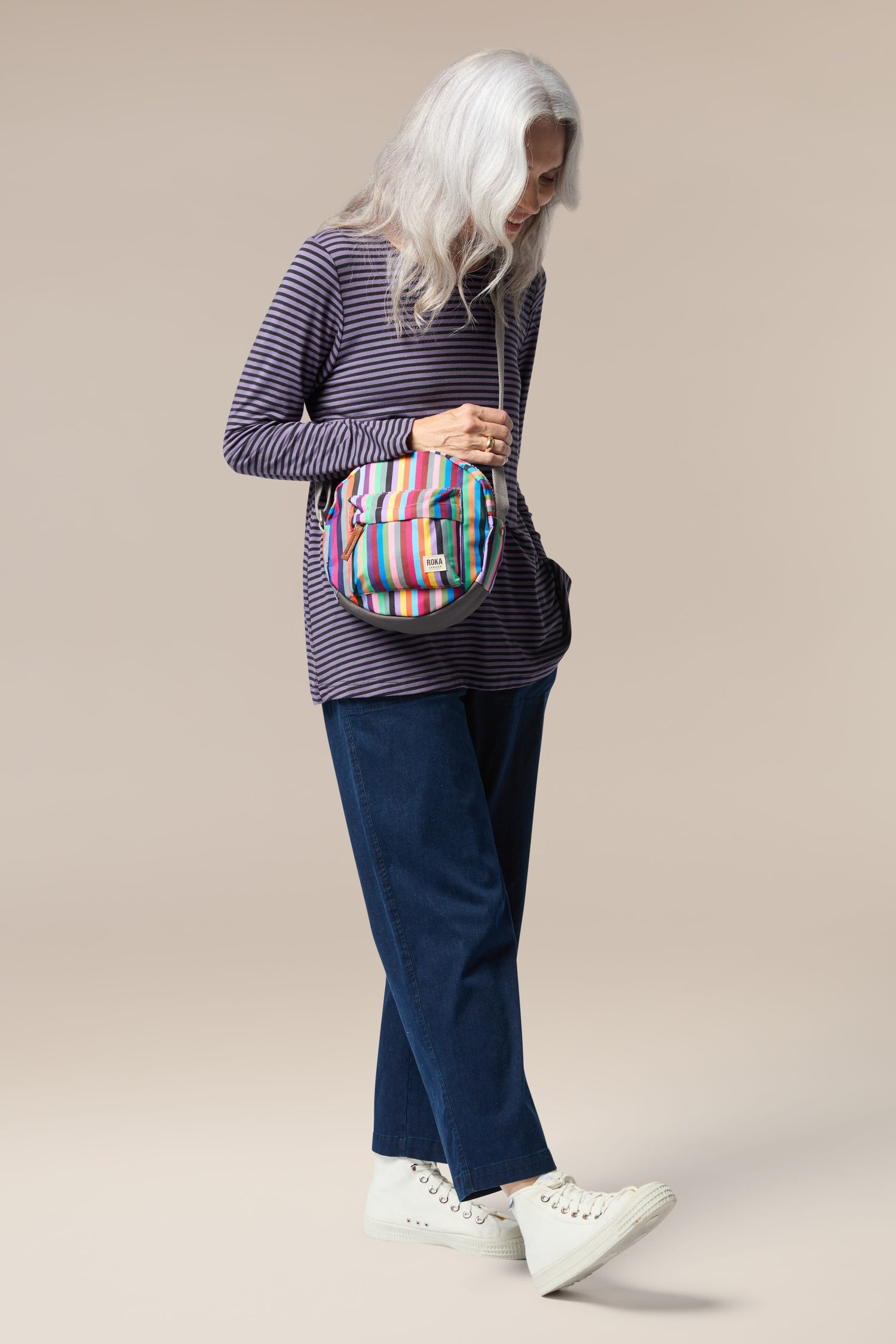 A woman is holding a lightweight, weather-resistant Recycled Canvas Paddington Bag.