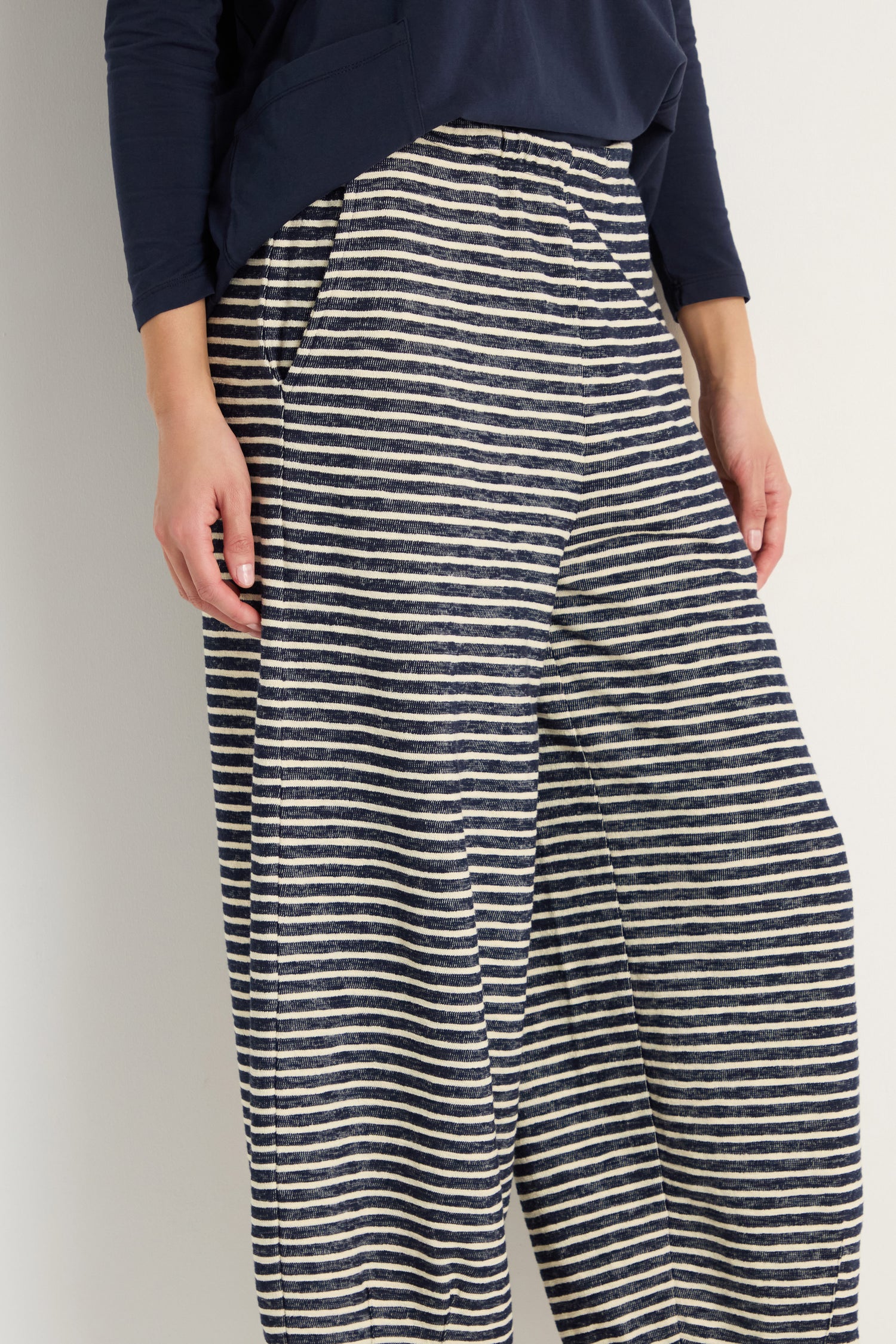 A person wears Textured Stripe Jersey Bubble Trousers with an elasticated waist and a navy long-sleeve top, standing against a plain background.