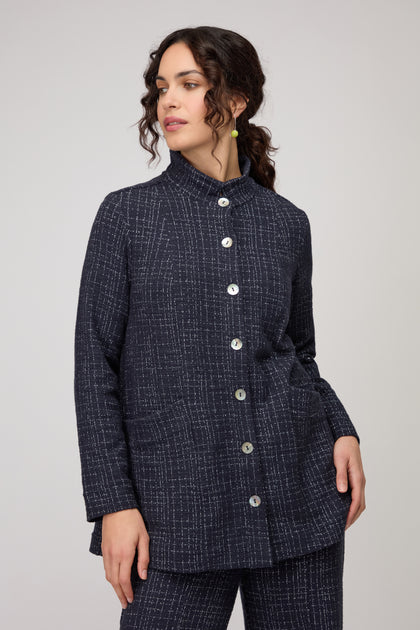 Woman wearing the Boucle Cotton Jersey Jacket in navy blue with matching pants, standing against a plain light background.