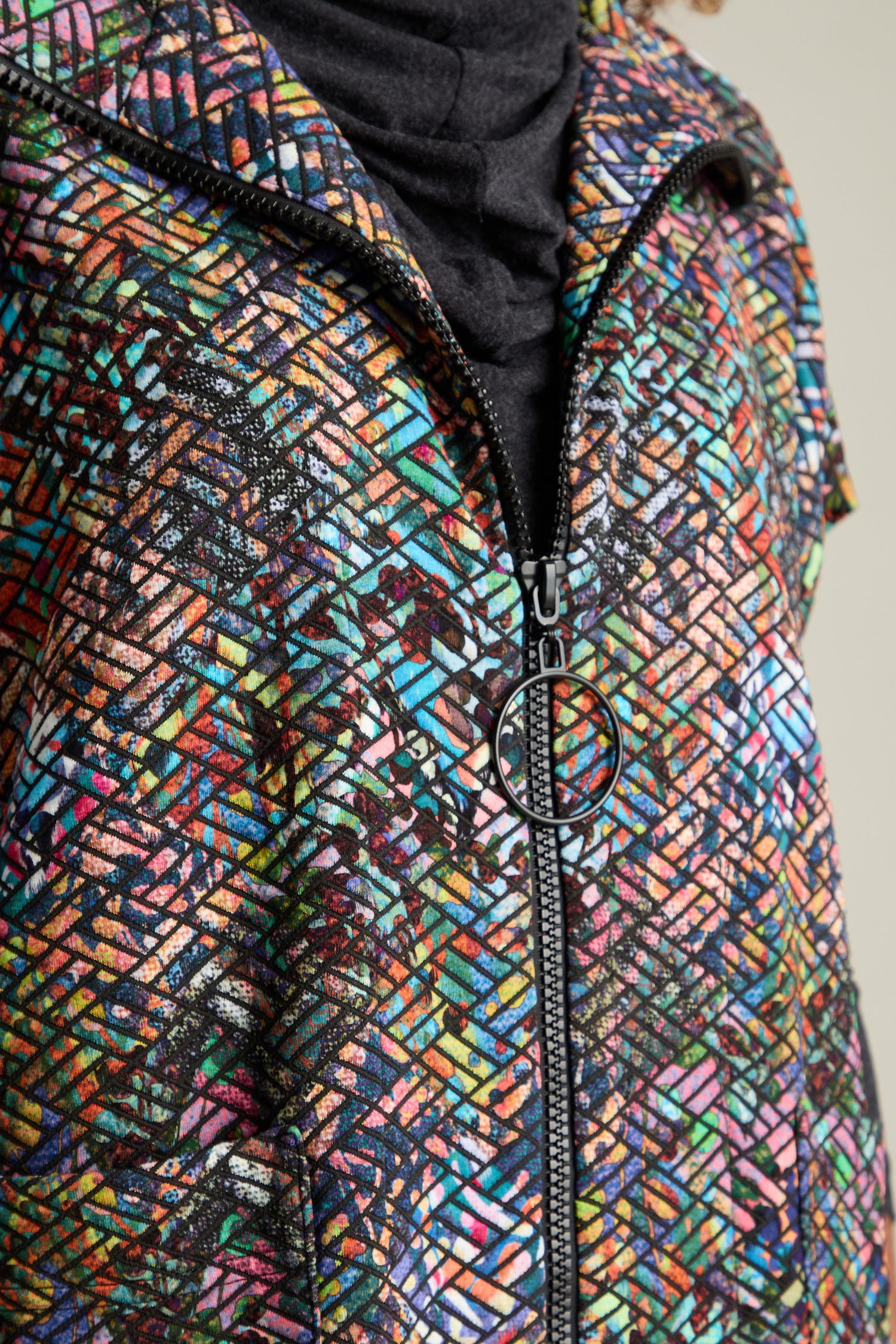 Close-up of the Diamond Jacquard Jersey Jacket, a modern silhouette crafted from multi-coloured diamond jacquard fabric, featuring a central zipper.