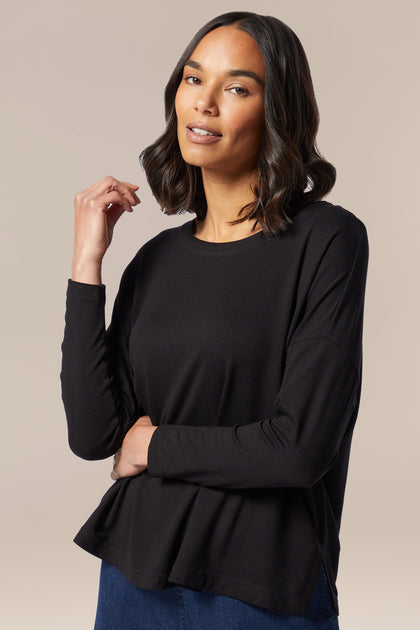 A woman wearing a Fluid Crepe Relaxed Top from her wardrobe.