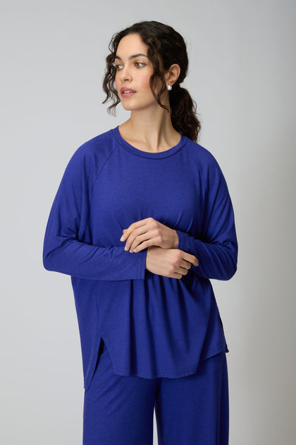 A person in the Soft Viscose Jersey Boxy Top and matching blue relaxed-fit pants stands against a plain light background, gazing slightly to the side.