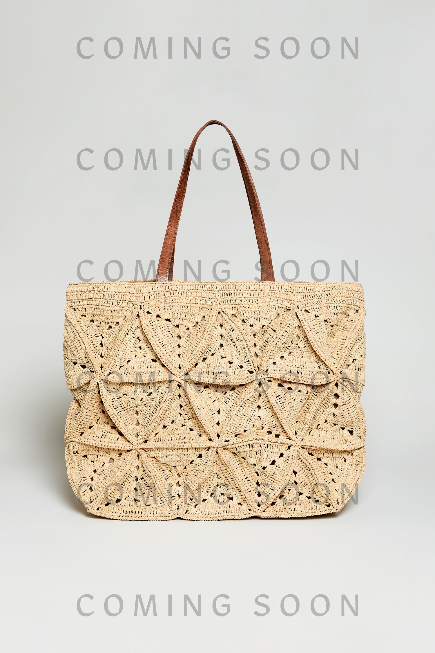Handwoven Raffia Basket Bag, style code TON12163, features beige woven material and brown handles, shown on a plain background. "COMING SOON" is repeated over the image.
