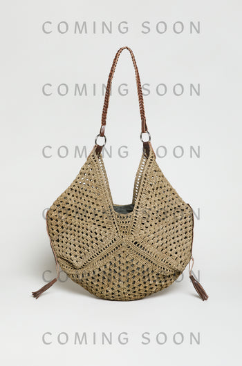The Handwoven Raffia Tassel Detail Handbag features brown leather handles and tassel accents. Displayed against a plain background, the image includes a "COMING SOON" overlay. Style TON12315.