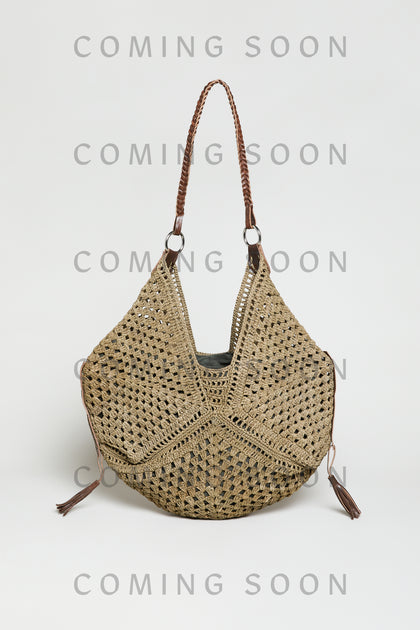 The Handwoven Raffia Tassel Detail Handbag features brown leather handles and tassel accents. Displayed against a plain background, the image includes a "COMING SOON" overlay. Style TON12315.