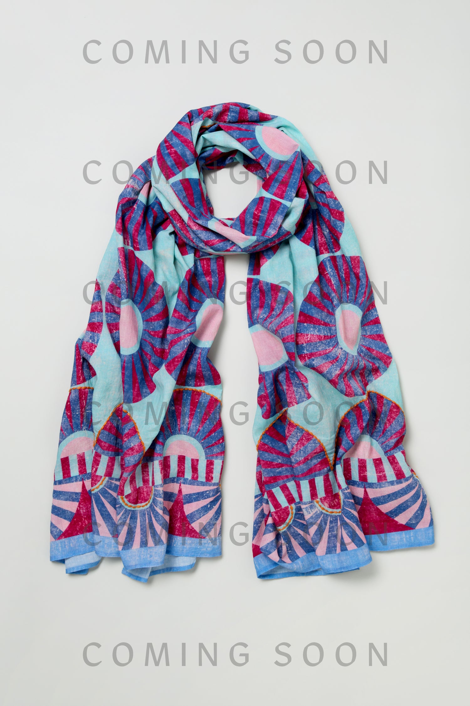 The Embroidered Parasols Cotton Scarf, featuring a blue and pink abstract sunburst pattern, is displayed against a light background with "COMING SOON" overlaid multiple times.