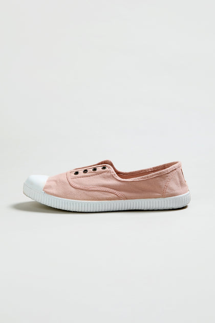 The Inglesa Light Pink Pumps, an online exclusive slip-on sneaker, features a white rubber toe cap and sole. Shown from the side against a plain background.