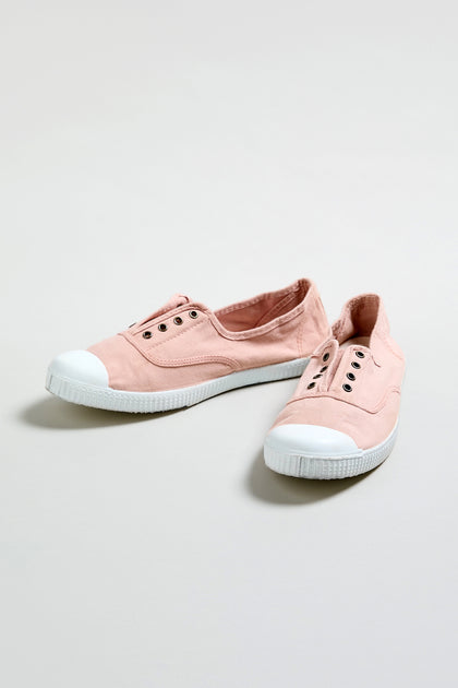 A pair of Inglesa Light Pink Pumps with white rubber toe caps, no laces, and metal eyelets rests on a plain light background. This is an online exclusive style.