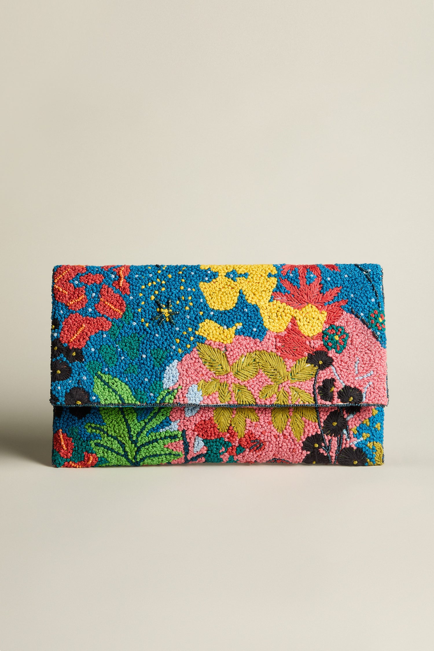 The Full Bloom Hand Beaded Clutch Bag, stylishly decorated with a vibrant array of floral designs, sits gracefully against a plain white background.