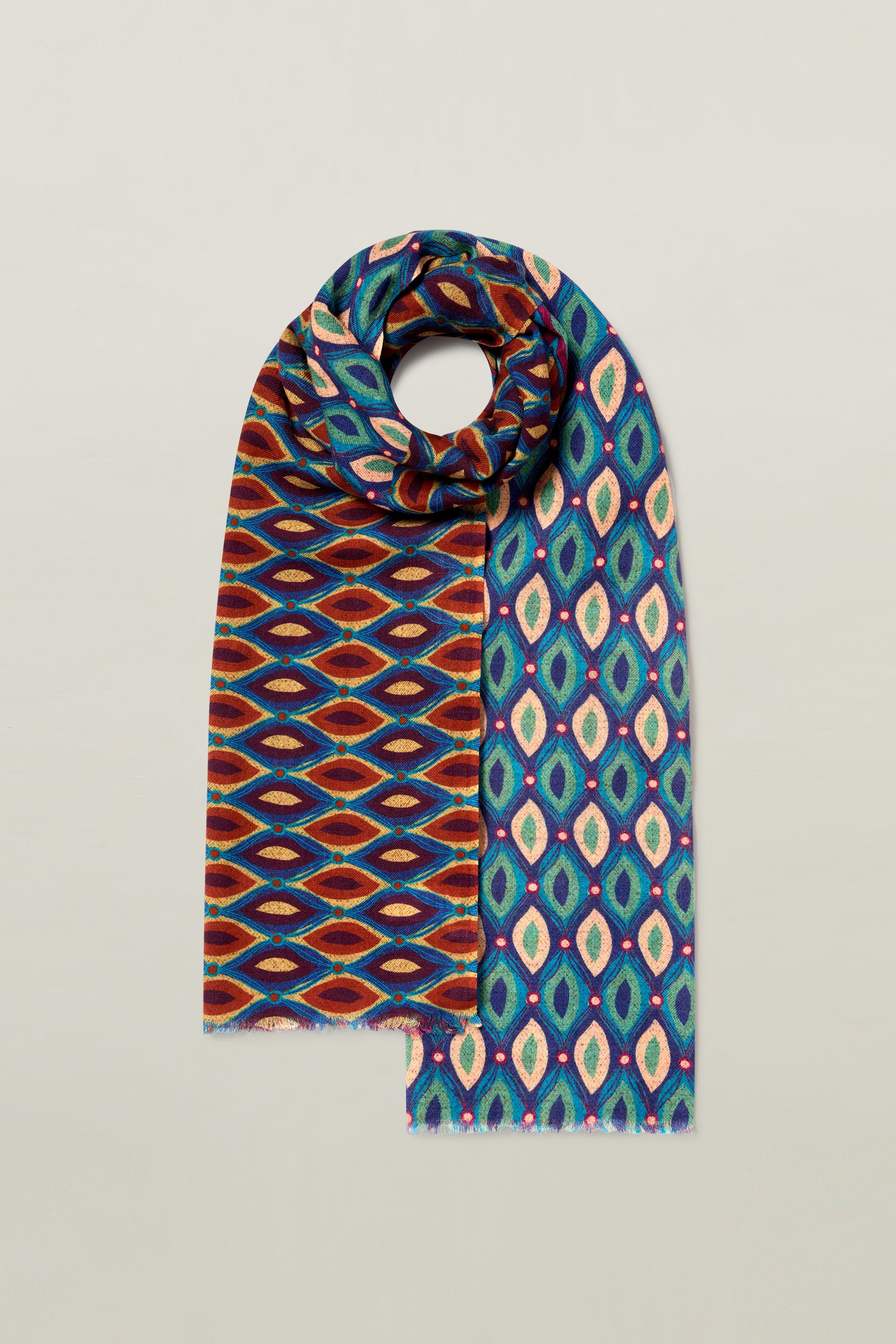 The Retro Wool Twill Scarf showcases two distinct geometric patterns: one side displays red and blue diamonds, while the other features green, blue, and pink diamond shapes. The luxurious design is beautifully draped in a circular wrap.