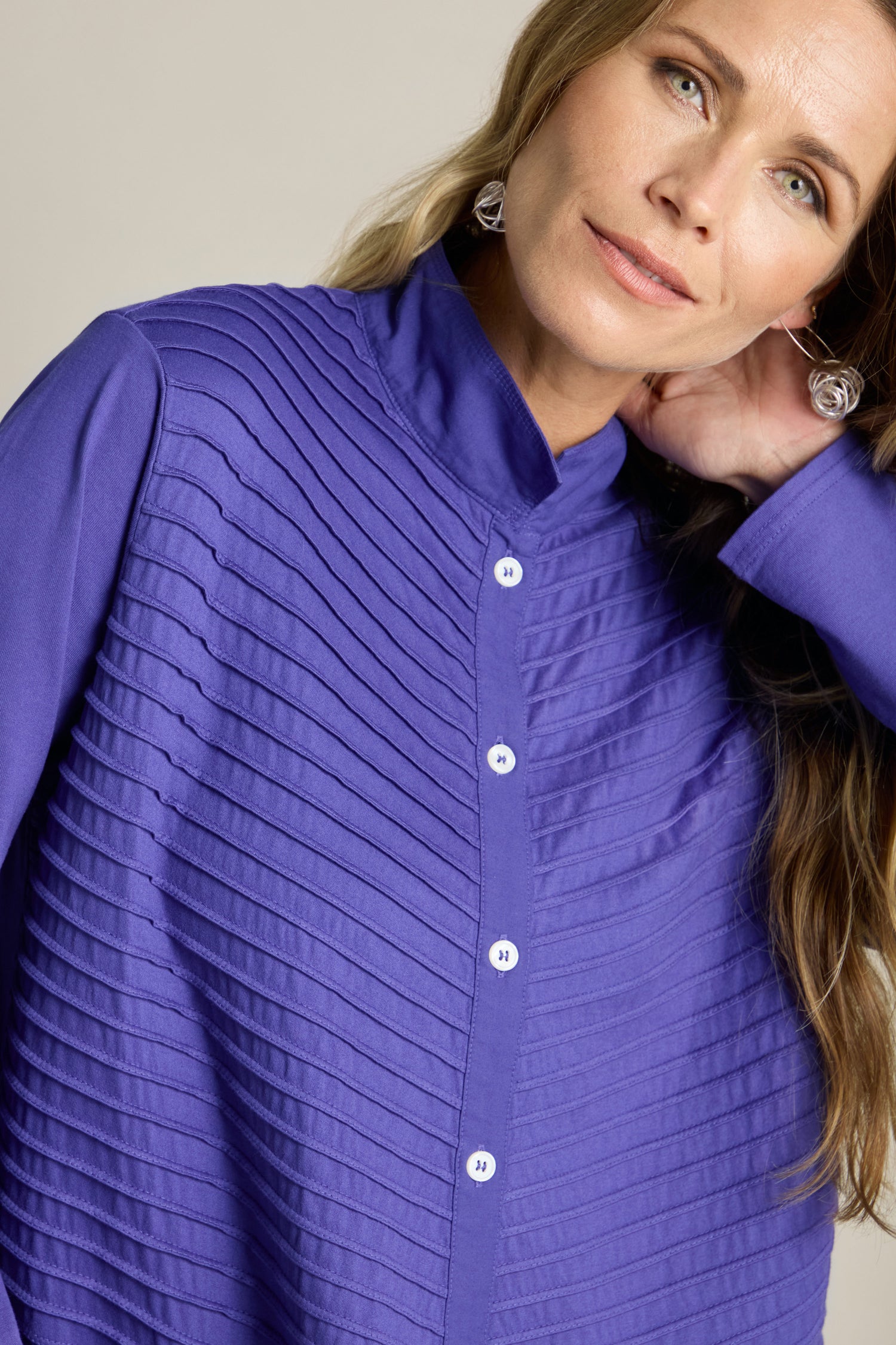 A person wearing a blue Cotton Jersey And Calico Overshirt with an embroidered placket is posing with one hand behind their head.