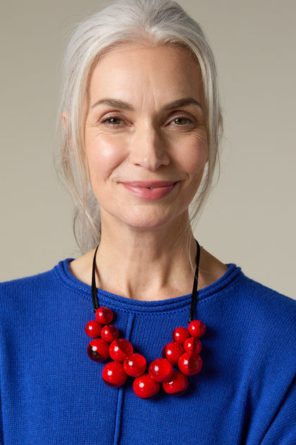 A woman wearing a blue sweater and a Spheres Necklace.