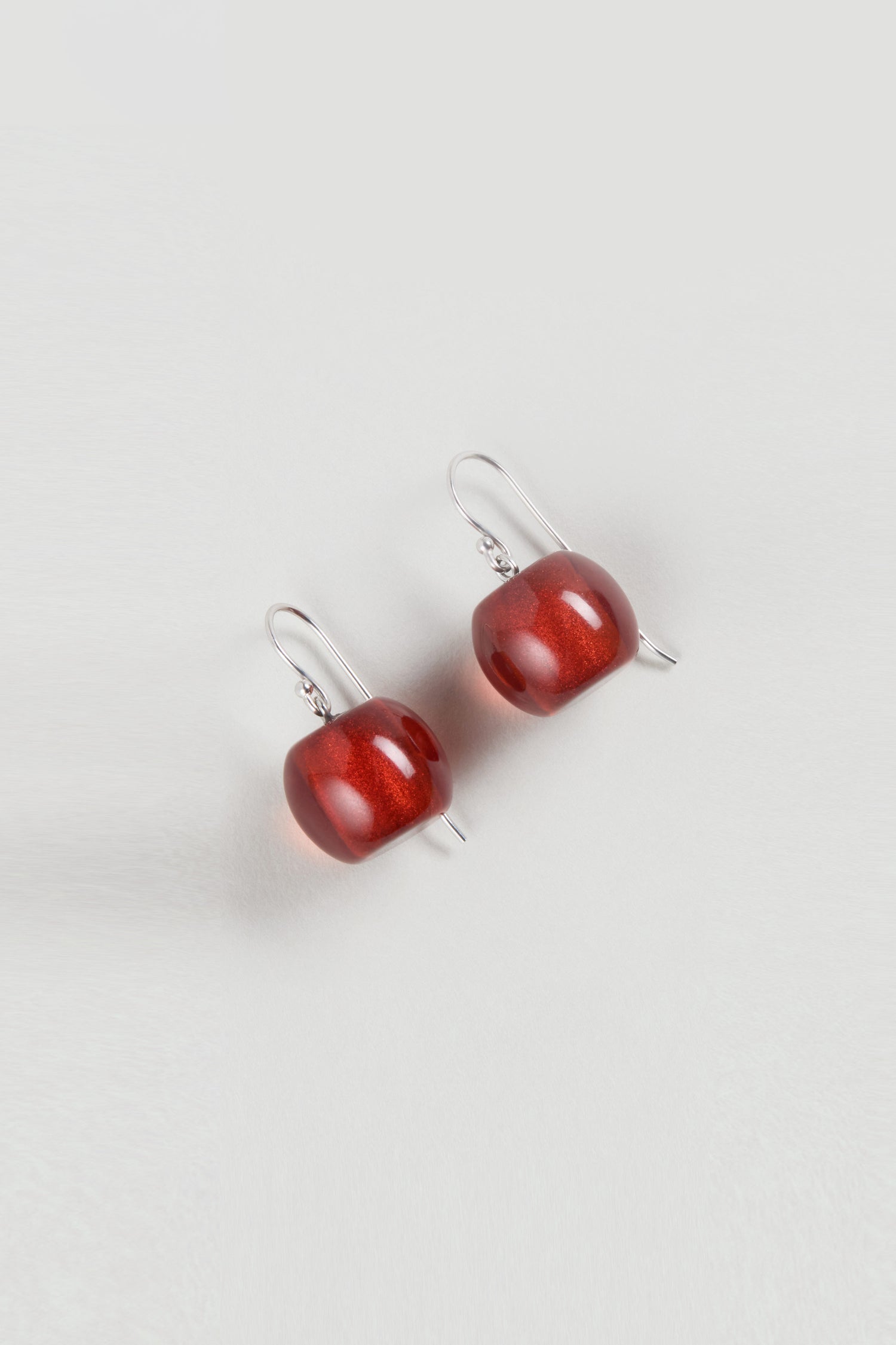 Showcasing the Colourful Bead Resin Earrings—silver hook earrings with round, glossy red beads on a plain white background. Ideal for lovers of vibrant bead earrings and modern jewellery.