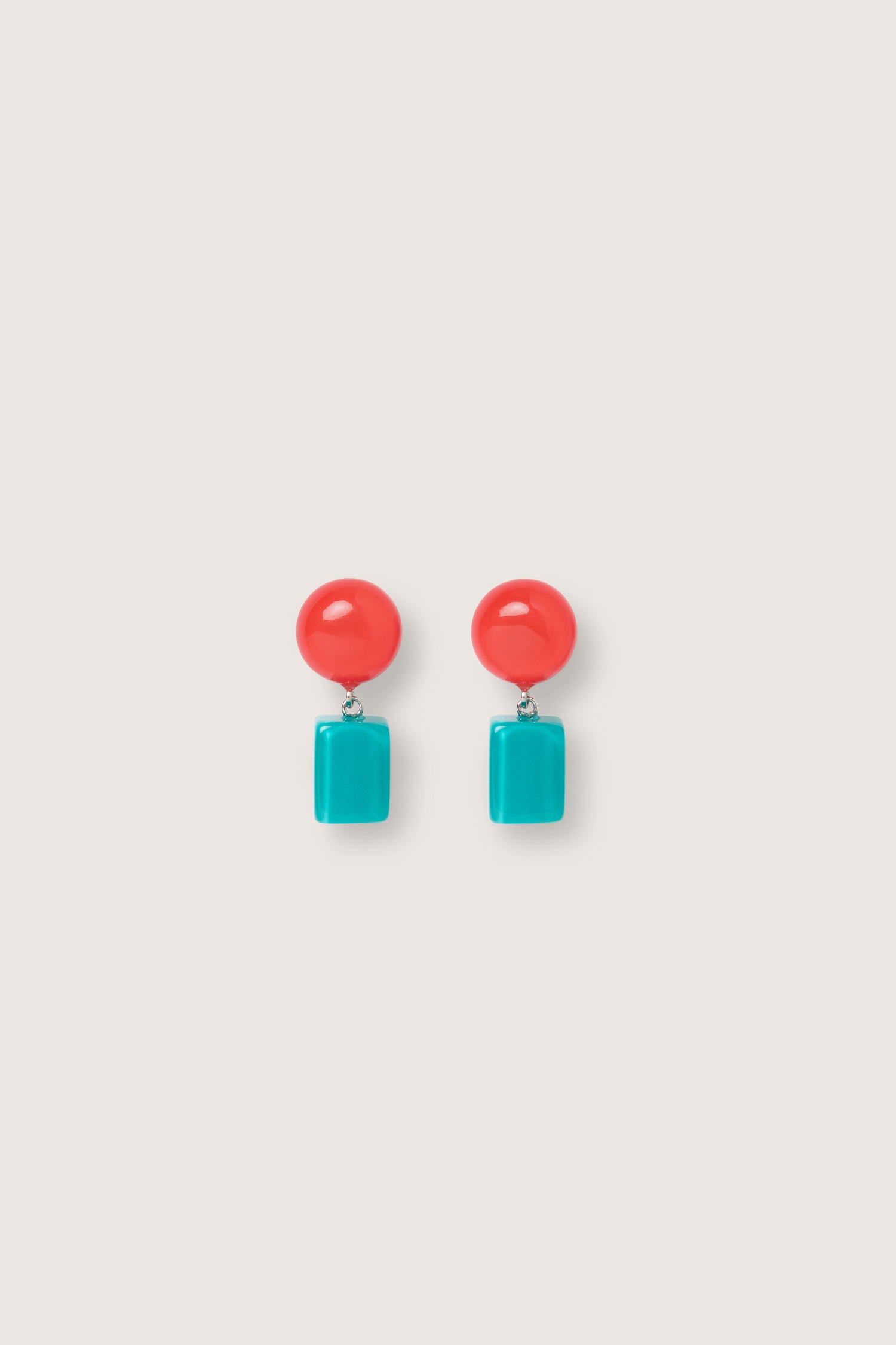 A pair of Sphere and Cube Resin Earrings featuring a round red resin bead at the top and a rectangular turquoise bead at the bottom, set against a plain light background.